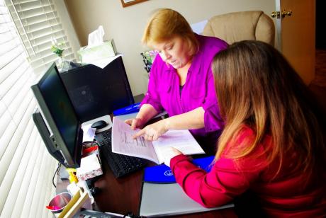 Family Services Case Manager Rebecca Peter goes over the Allstate Foundation curriculum with Jana. 